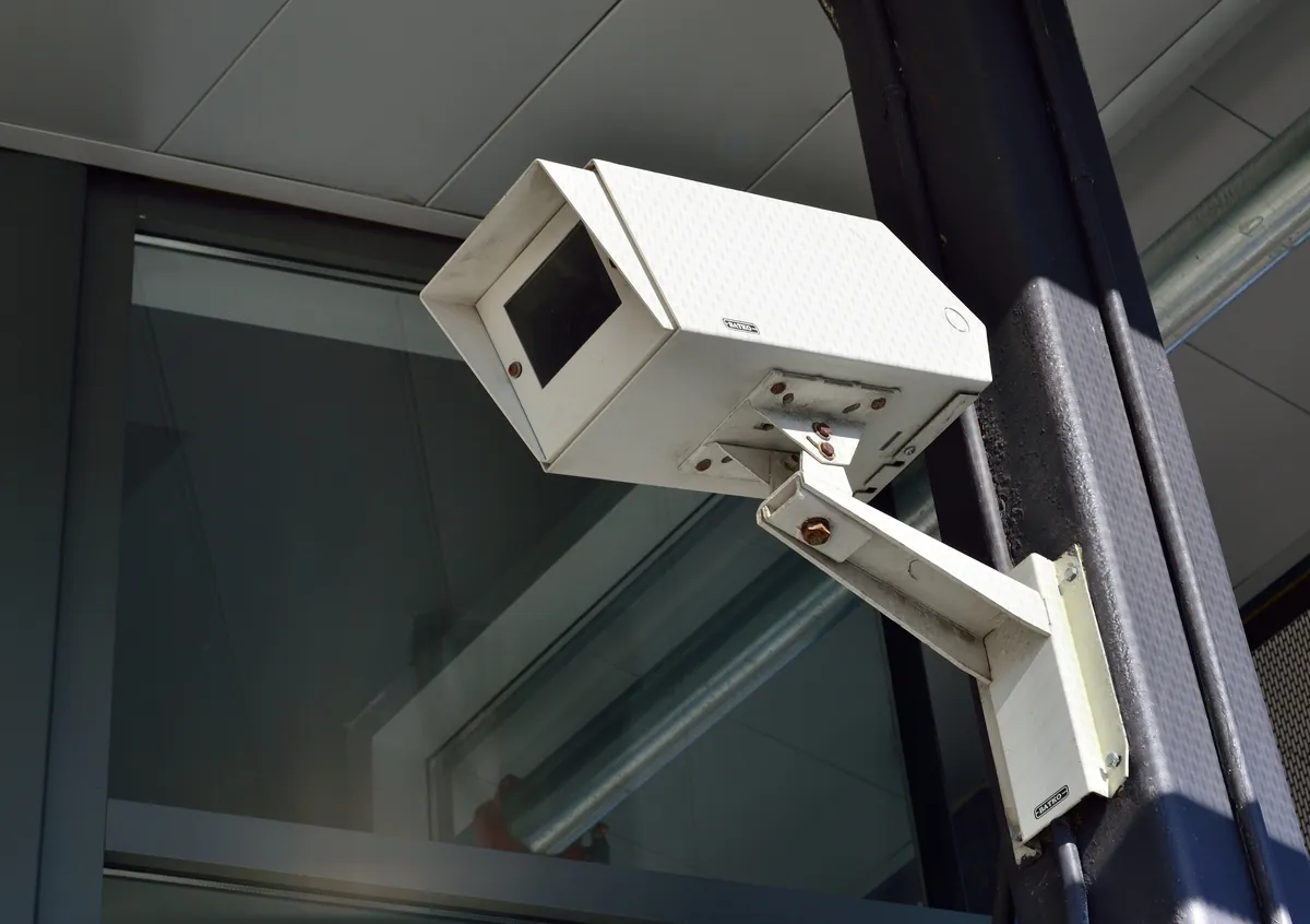 A wall-mounted security camera outside a retail store